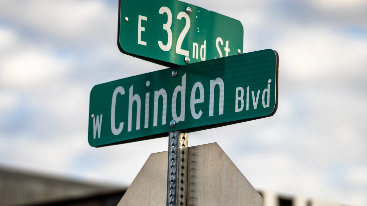 Green Chinden Boulevard and East 32nd Street signs against a softly blurred background.
