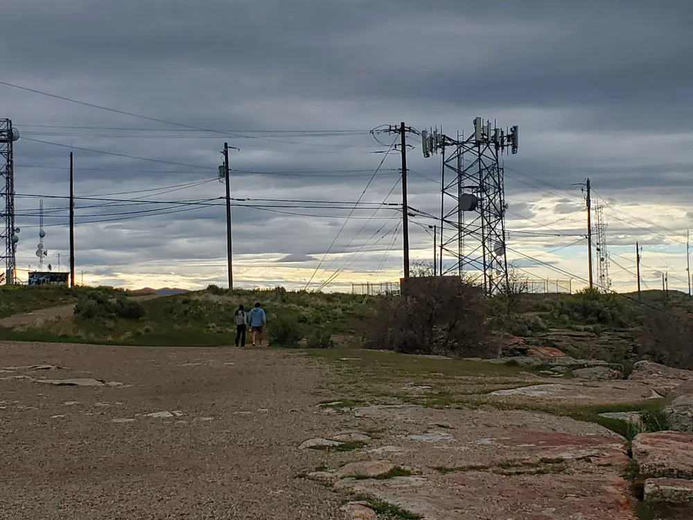 Two people walking at Table Rock beneath utility lines and communications towers